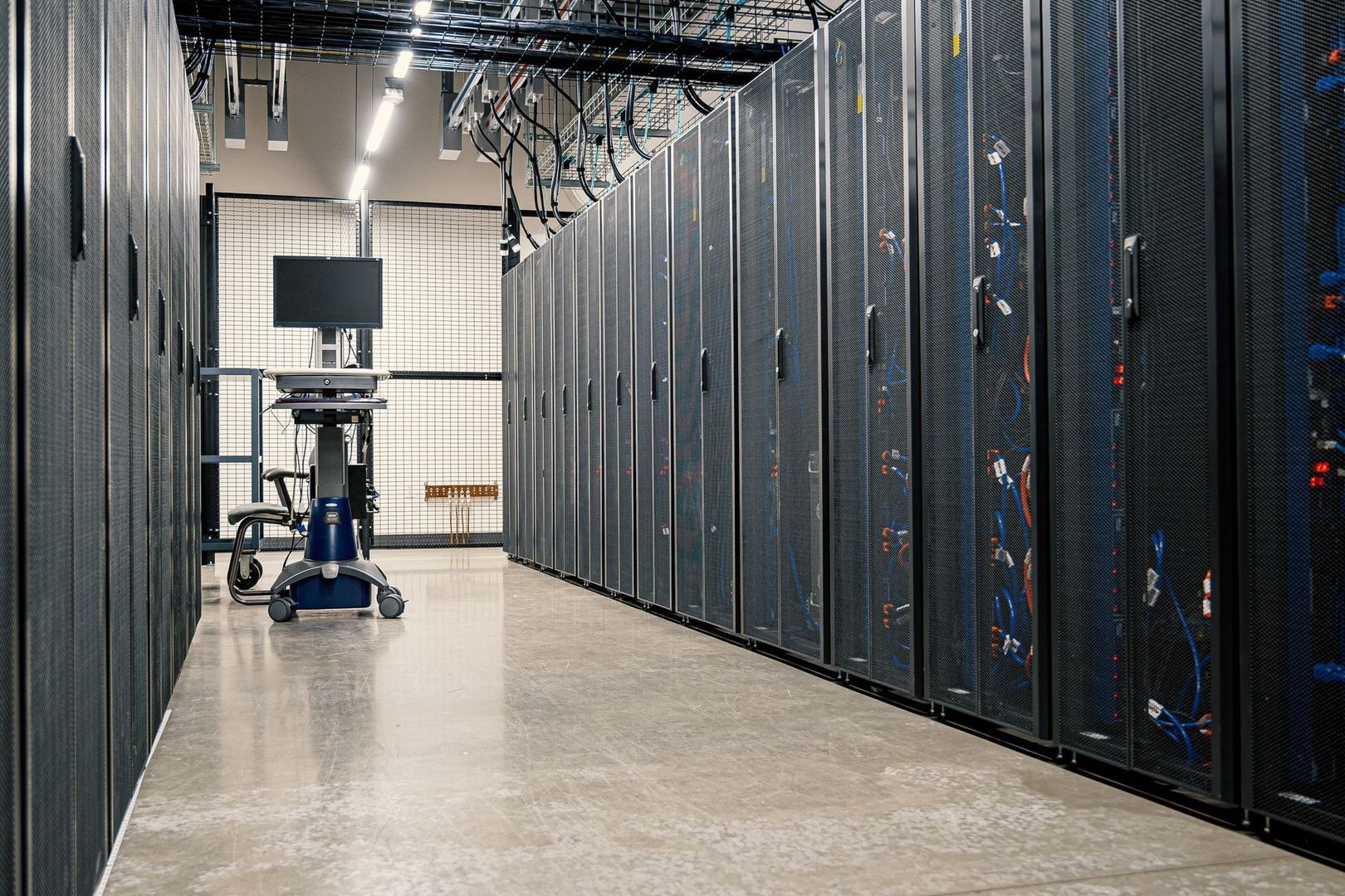Rows of enclosed server racks in a brightly lit data center